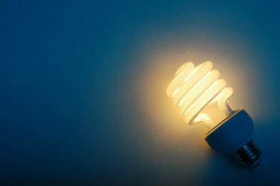 CFL light bulb on blue background