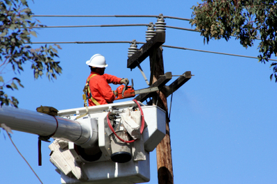 Man working on telephone pole during a power outage